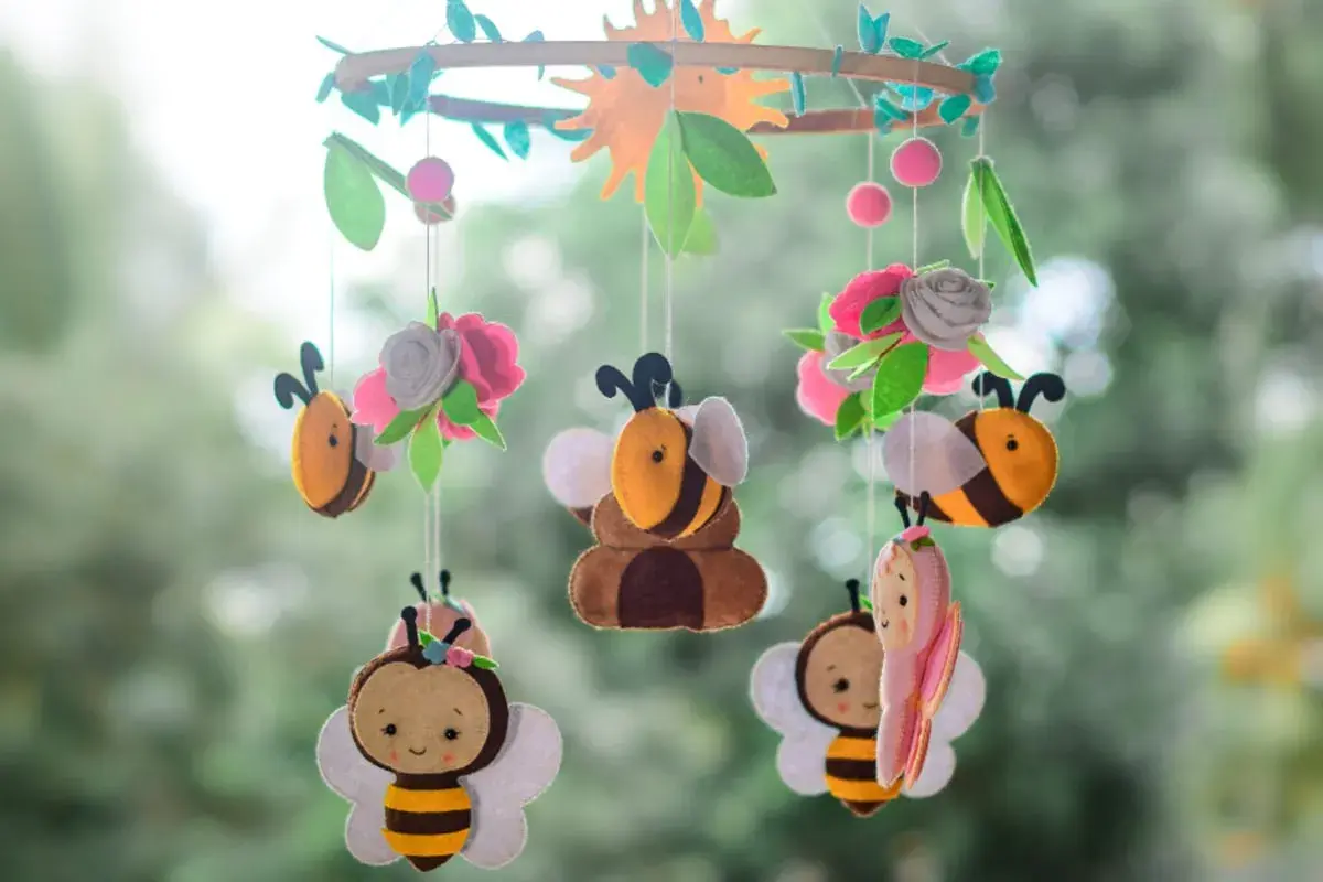 Niedliche Bienen und Blumen aus Filz, ein tolles Beispiel für **handy basteln** für ein Kinderzimmer.