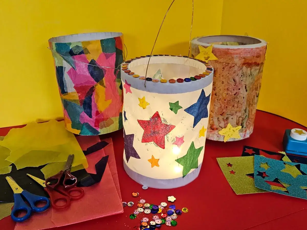 Bunte Laternen, die zum st Martin Laterne basteln Vorlage einladen. Bunte Sterne und Glitzer zieren die selbstgemachten Lichter.